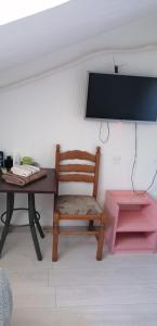 escritorio con silla y TV en la pared en Konak Aleksandar, en Mladenovac