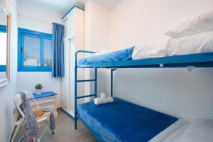 a room with two bunk beds and a chair at Riva Eco Guest House in Los Abrigos