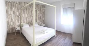 1 dormitorio con cama blanca con dosel y suelo de madera en Casa Rural - Santo Domingo Rural, en Archidona