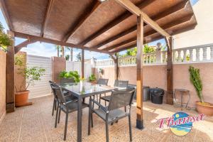 patio con tavolo e sedie sotto un pergolato di Casa Dario a Gran Alacant