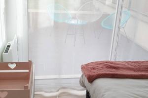 um quarto com uma cama e uma parede de vidro em Cocon à la campagne - Disney 20 min - Paris 40 min - 2 terrasses em Dammartin-sur-Tigeaux