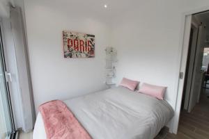 um pequeno quarto com uma cama com almofadas cor-de-rosa em Cocon à la campagne - Disney 20 min - Paris 40 min - 2 terrasses em Dammartin-sur-Tigeaux