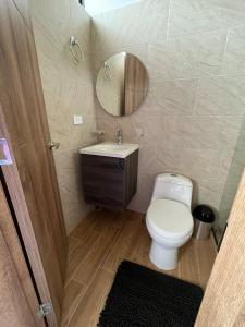 La salle de bains est pourvue de toilettes, d'un lavabo et d'un miroir. dans l'établissement Casa Campestre Altamira, à Los Curos
