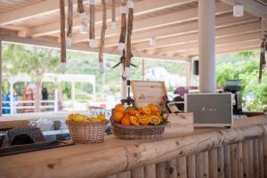 a counter with two baskets of oranges and a laptop at Soleil Village & Villas in Jal