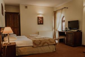 a bedroom with a bed and a desk and a television at Olandia in Kwilcz