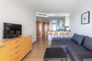 Paradero Rental B74- Vistas al Mar في كاليبي: غرفة معيشة مع أريكة وتلفزيون بشاشة مسطحة