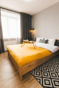 1 dormitorio con 1 cama grande con manta amarilla en BAVOVNA Нова комфортна 2-кімн. квартира в ЖК Енергія, en Ternopilʼ