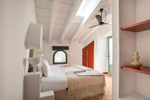 a white bedroom with a bed and a ceiling fan at Menorca Experimental in Alaior