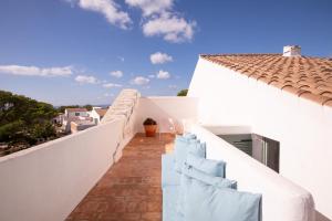 a balcony of a white house with blue chairs at Menorca Experimental in Alaior
