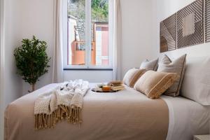 a white bedroom with a large bed with a window at Olives Bay Terrace in Portofino in Portofino