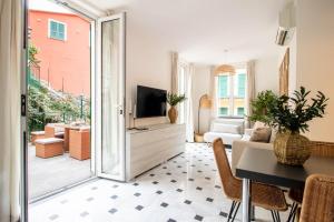 een woonkamer met een televisie en een tafel en stoelen bij Olives Bay Terrace in Portofino in Portofino