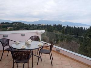 a table and chairs on a balcony with a view at Palazzo con Vista in Corfu