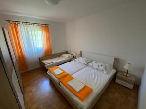a bedroom with a large bed with an orange blanket at Apartman Maria in Crikvenica