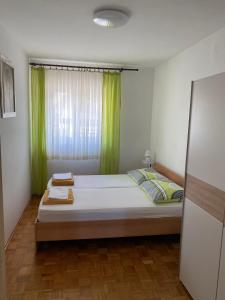 a bedroom with a large bed with green curtains at Apartman Maria in Crikvenica