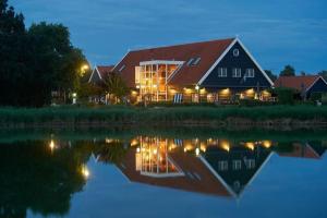 una casa con un reflejo en el agua por la noche en Oengs Huus, en Heinkensand