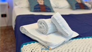 un mucchio di asciugamani seduti sopra un letto di Madò Apartments Egnazia a Bari
