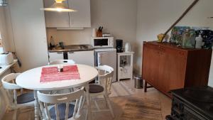 a small kitchen with a white table and chairs at Fageredsgården in Ullared