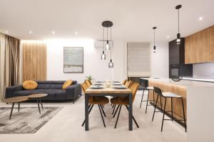 a kitchen and living room with a table and chairs at Leonardo Luxury Residence 2 Penthouse with jacuzzi in Zadar