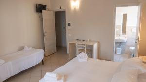 a room with two beds and a bathroom with a sink at Hotel La Smorfia in Castiglioncello