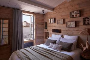 um quarto com uma cama e uma parede de madeira em Maisons 322 - La Secrète em Le Bois-Plage-en-Ré