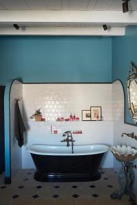 uma casa de banho com uma banheira preta e uma parede azul em Maisons 322 - La Secrète em Le Bois-Plage-en-Ré
