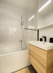y baño blanco con lavabo y ducha. en BaMo Studio - modern living lakeside en Klagenfurt