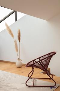 einen Stuhl in einem Raum mit einer Vase in der Unterkunft Jardin des Anges - Castillet view - WIFI- Centre ville in Perpignan