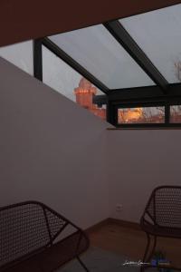 Zimmer mit 2 Stühlen und einem großen Fenster in der Unterkunft Jardin des Anges - Castillet view - WIFI- Centre ville in Perpignan