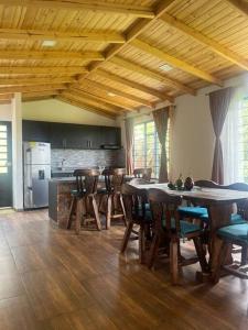 a dining room with a table and chairs and a kitchen at Cabaña Campestre Montreal in Paipa