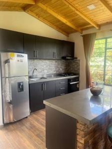 a kitchen with a stainless steel refrigerator and a counter at Cabaña Campestre Montreal in Paipa