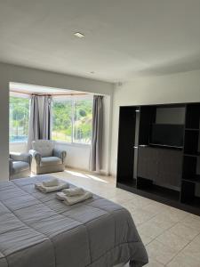 a bedroom with a bed and a flat screen tv at La Herradura Village in Merlo