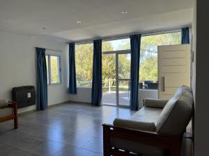 ein Wohnzimmer mit einem Sofa und großen Fenstern in der Unterkunft La Herradura Village in Merlo