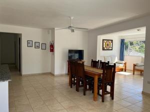 a dining room and living room with a table and chairs at La Herradura Village in Merlo