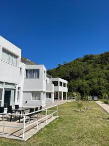 ein weißes Gebäude mit einem Haufen Stühle in einem Hof in der Unterkunft La Herradura Village in Merlo