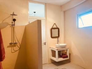 La salle de bains est pourvue d'un lavabo blanc et d'une fenêtre. dans l'établissement Villa at secured gated resort near Mambo Beach!, à Willemstad