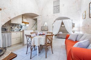 uma cozinha e sala de estar com uma mesa e um sofá em Portici Guest House by Rentbeat em Fasano