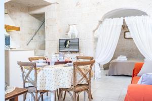 uma sala de jantar com mesa e cadeiras em Portici Guest House by Rentbeat em Fasano