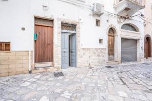 uma rua vazia com portas e um edifício em Portici Guest House by Rentbeat em Fasano