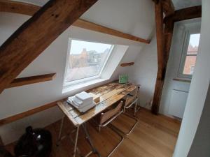 een kleine kamer met een houten tafel en een raam bij De Zomere B&B in Brugge
