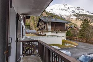 un balcón de una casa con una montaña cubierta de nieve en Appartement 5 à 6 personnes en Les Contamines-Montjoie