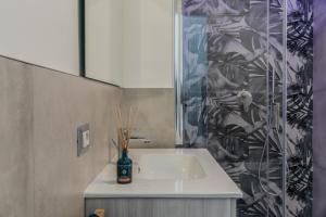 une salle de bain avec un lavabo et une douche en verre dans l'établissement Cagliari Modern Studio near the Station!, à Cagliari