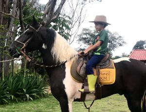 een jonge jongen zit op een paard bij Haras KM in Bom Jesus do Amparo