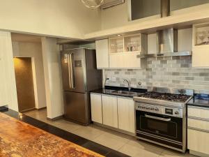 a kitchen with a stove and a refrigerator at Estancia Alto San Pedro in Huerta Grande