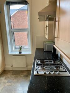 a kitchen with a stove top oven next to a window at Heswall apartment in Wirral