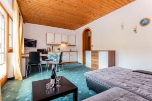 een slaapkamer met een bed, een keuken en een tafel bij Appartements Dreimäderlhaus in Maria Alm am Steinernen Meer