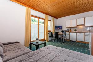 1 dormitorio con 1 cama y cocina con mesa en Appartements Dreimäderlhaus, en Maria Alm am Steinernen Meer