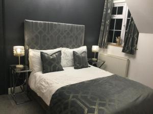 een slaapkamer met een bed met een grijs hoofdeinde en 2 lampen bij The Smithy in Hay-on-Wye