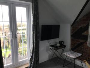 a living room with a flat screen tv and a window at The Smithy in Hay-on-Wye