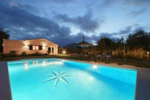 a large swimming pool in front of a house at Villa Antonia, Pollença in Pollença