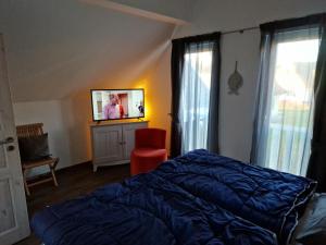 - une chambre avec un lit et une télévision à écran plat dans l'établissement Haus Sandra Glowe, à Glowe
